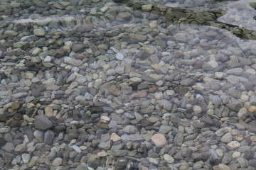 Fototapeta na wymiar viele kleine Steine im sauberen klaren Wasser
