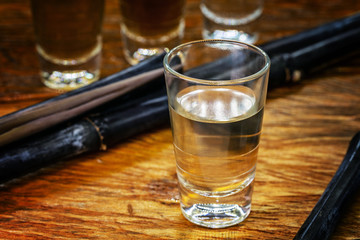 Several glasses of brazilian cachaça isolated on rustic wooden background, variations and types of brazil cachaça, typical drink from brazil.