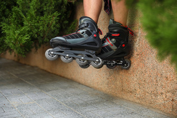 Young man with roller skates outdoors, closeup