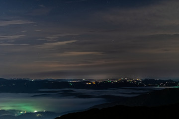 Fototapeta na wymiar The view of the mountains surrounding Boone North Carolina at night with low lying cloud inversion and glowing city lights