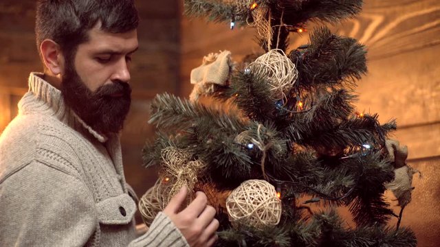 Berded santa decorate the Christmas tree. Hipster Santa wishes merry christmas. Theme Christmas holidays winter new year. Christmas decorations.