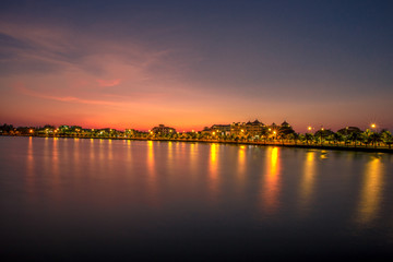 Fototapeta premium Blurred wallpaper of colorful, twilight sky by the sea, with lights from the street shining at night, beautiful natural occurrences, seen in scenic spots or tourist attractions. B โดย Bangprikphot