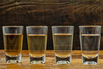 glasses of brazilian cachaça isolated on rustic wooden background. It is used in the preparation of the worldwide known cocktail caipirinha. traditional drink from brazil