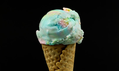 Closeup Ice cream Rainbow colorful scoop in waffle cone on black background, Closeup Front view Food concept..