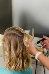 Barber braids high braid. Hairdressing services. Creating evening hairstyles fashionable stylish women's hairstyles. Process of hair styling. Courses in hairdressing. Beauty salon concept.