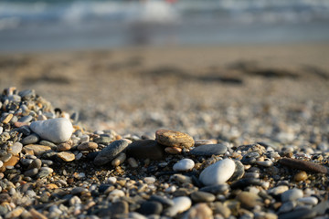 Wet sea pebbles and seashells on a wet sandy beach. Natural sea stones close-up. Beach smooth pebbles close-up. selective focus. Tourism and travel themed.
