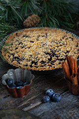 Winter tart with frozen berries. Homemade tart with blueberry and crumble. Vintage baking dish and a spatula for cake