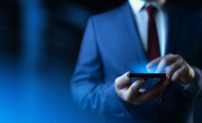 Businessman holding smartphone. Man using phone in office