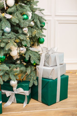 Christmas presents/gifts under fir-tree. Vintage New Year decorations. Red gift boxes and lantern under fir-tree. Christmas mood. Celebrating of New Year