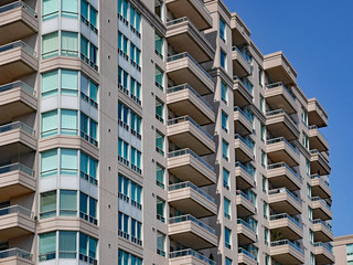 modern apartment building with balconies and green tinted windows