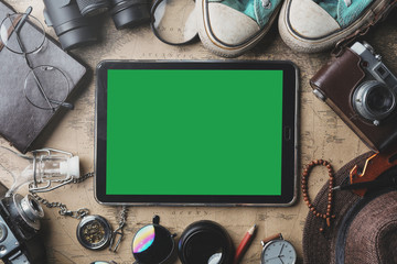 Green Screen on Tablet, Travel Concept Background. Overhead View of Traveler's Accessories on Old...
