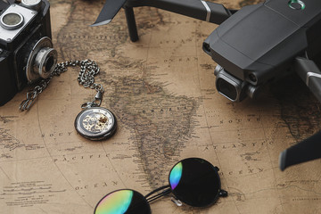 Travel With Drone Concept Background. Drone Between Traveler's Accessories on Old Vintage Map