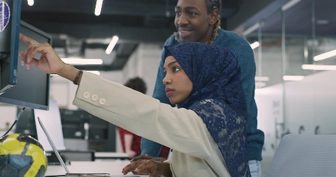 Young multiethnic business team of software developers working together using