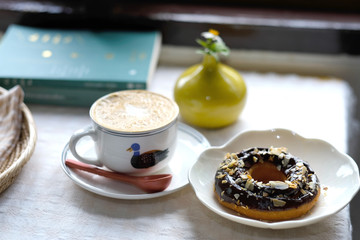Closeup image of a small  vase and books on table in minimal cafe - Image