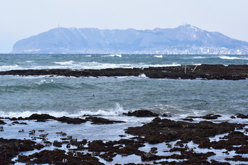 Fototapeta na wymiar 荒れた津軽海峡と冬の函館山