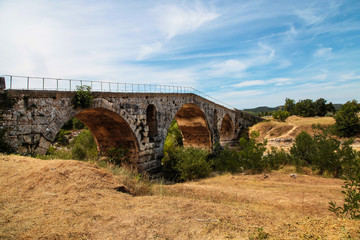 Fototapeta na wymiar Charming stone bridge across mountain river. France.