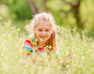 Child resting on green field