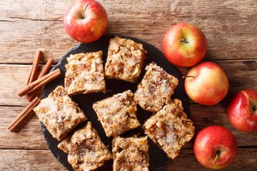 Homemade apple blondies with cinnamon and nuts close-up on a slate board. Horizontal top view