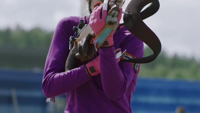 Portrait of Caucasian female professional biathlete practicing on a shooting range during mid-season practice in summer. ARRI Alexa Mini with Cooke S4 prime lenses RAW graded footage