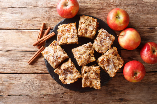 Sliced apple blondies with cinnamon and nuts close-up on a slate board. horizontal top view