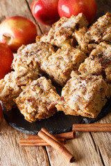 Homemade apple blondies with cinnamon and nuts close-up on a slate board on the table. vertical