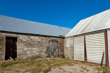 Fototapeta na wymiar The Corner of a Farm yard with Tin covered Roofed Farm Buildings.