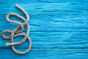 Mooring rope on blue wooden table background with a copy space. Sea travel concept.
