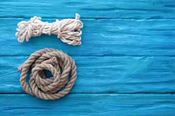 Fototapeta premium Mooring rope on blue wooden table background with a copy space. Sea travel concept.