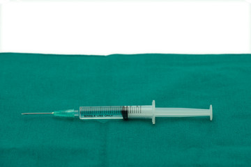 Liquid parenteral products in syringe isolated on surgical green drape fabric with white space for text copy