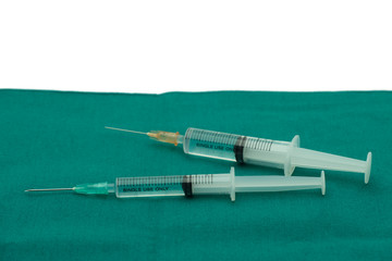 Liquid parenteral products in syringe isolated on surgical green drape fabric with white space for text copy