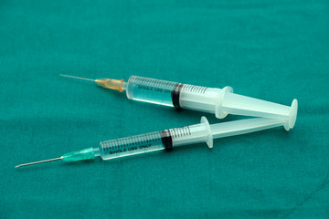 Liquid parenteral products in syringe isolated on surgical green drape fabric
