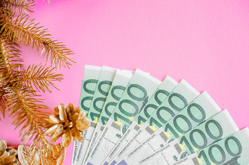 Christmas, money on a pink background near Christmas attributes