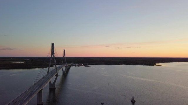 Aerial, tracking shot flying over the iconic Raippaluodon silta, Replot bridge at sunset in the Kvarken archipelago, Finland's longest bridge located in Ostrobothnia, Finland on a sunny summer evening