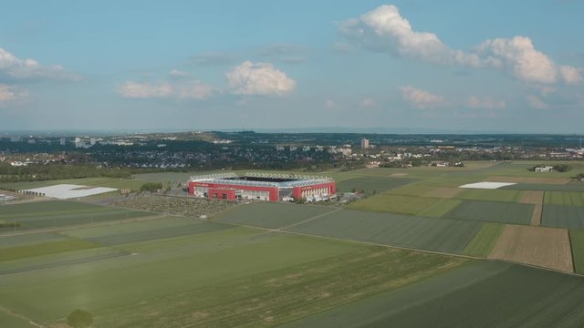 Drone / Aerial shot of the football stadium of the bundesliga team FSV Mainz 05 with field in the foreground on a sunny day, 25p