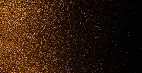 Golden grains on black background. Dust cloud pattern. Blur glitter powder.
