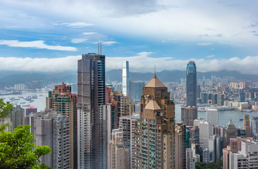 Fototapeta na wymiar Hong Kong Skyscraper and Victoia Harbor on blue cloudy sky from Peak Tower near the summit of Victoria Peak, Hong Kong China.