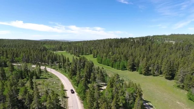 Road of Beartrap Meadow outskirts on sunny day. Wyoming USA. Aerial circle pan