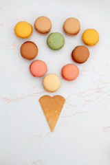 Fun flat lay composition of the colorful and sweet tasting small French cake macaron or macaroon combined with cookies