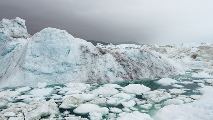 Fototapeta na wymiar Climate Change and Global Warming - Icebergs from melting glacier in icefjord in Ilulissat, Greenland. Image of arctic nature ice landscape. Unesco World Heritage Site.