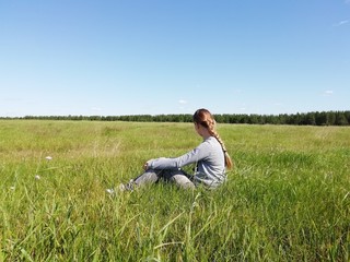 Naklejka na ściany i meble young woman sitting on grass