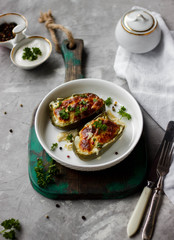Bulgarian pepper stuffed with eggplant, meat and cherry tomatoes. Baked sweet pepper with cheese on a grey background.