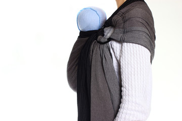 Obraz premium A newborn baby in a ringsling baby carrier in vertical position