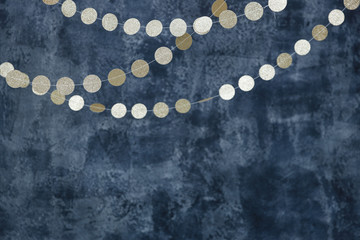 Gold garlands on a smoky dark blue background. Birthday and holiday decor.