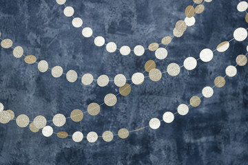 Gold garlands on a smoky dark blue background. Birthday and holiday decor.