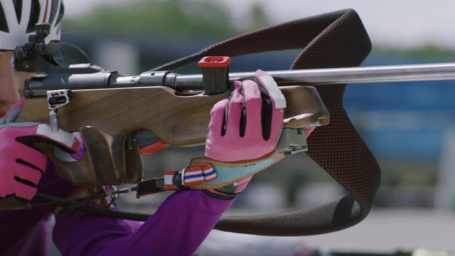 EXTREME CU Portrait of Caucasian female professional biathlete practicing on a shooting range during mid-season practice in summer. ARRI Alexa Mini with Cooke S4 prime lenses RAW graded footage