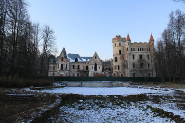 Fototapeta na wymiar Winter landscape with crumbling castle on the background of grass covered with snow