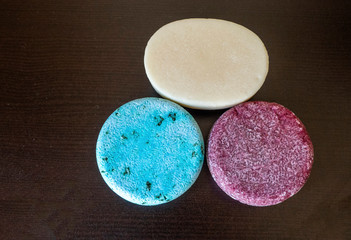 Assortment of Shampoo Bars and Conditioner bars on a dark table background