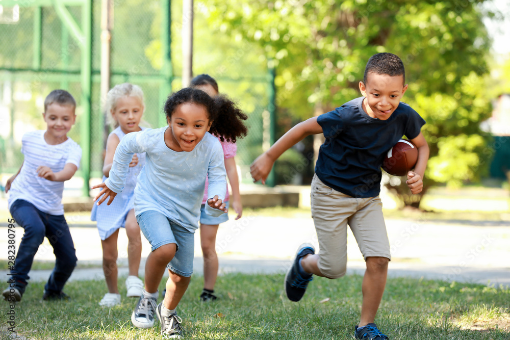 Canvas Prints Cute little children playing with rugby ball in park