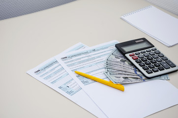 Obraz premium tax forms 1040, dollars, calculator and notepad on the table
