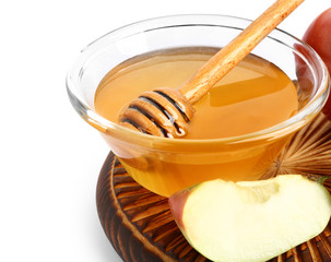 Bowl of fresh honey and apple on white background